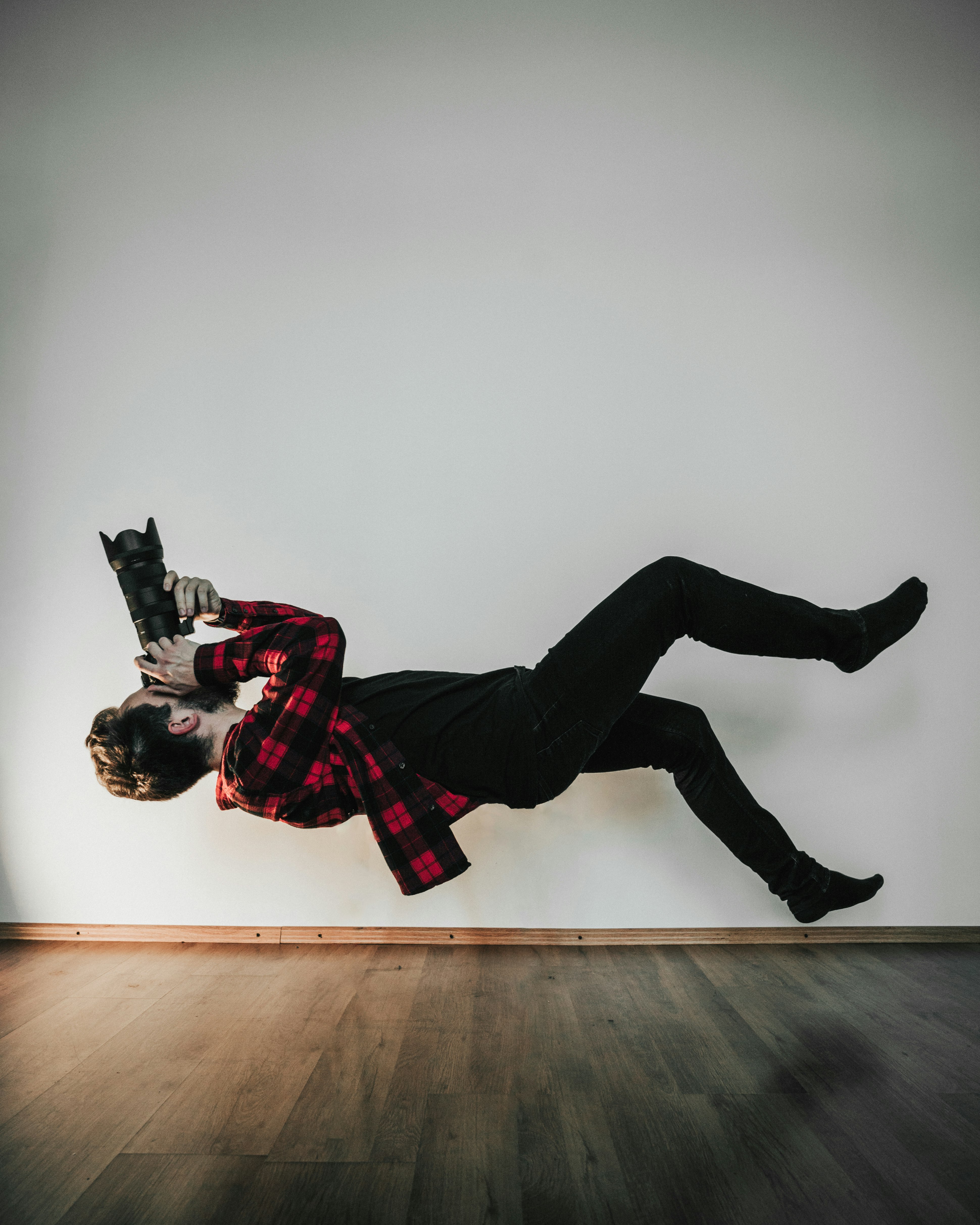 person in red and black plaid shirt and black pants wearing black boots